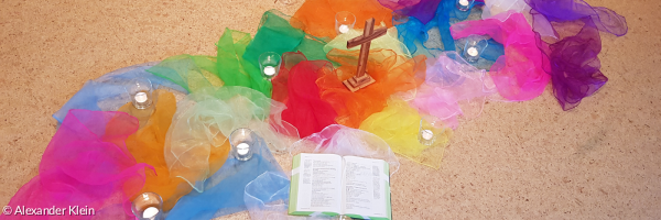 bunte Tücher auf dem Boden, ein Kreuz