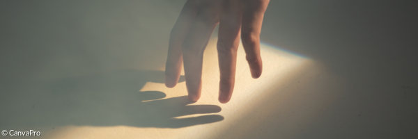 eine Hand berührt ihren eigenen Schatten